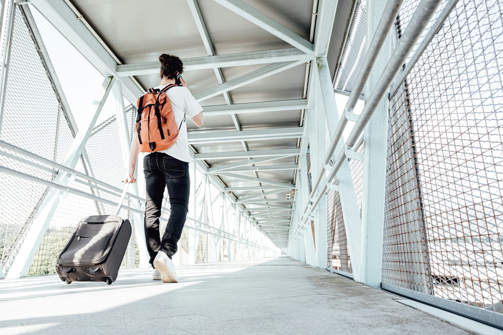 Young woman in an international airport with luggage and a passport